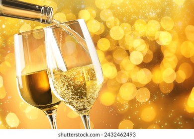 Pouring white wine into glass against golden background with blurred lights, closeup. Space for text - Powered by Shutterstock