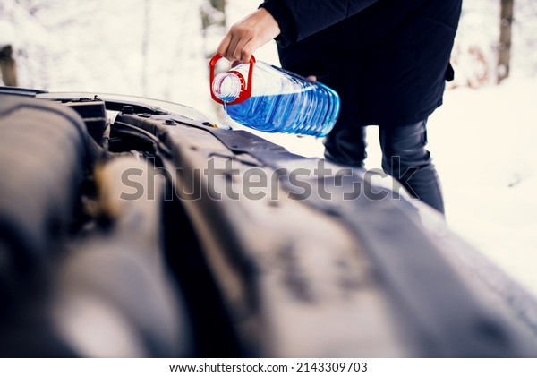 Pouring windshield fluid in\
car