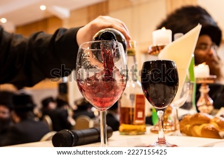pouring wine into glass and orthodox Jewish Hassidic wedding event.