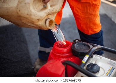 Pours gasoline from a barrel. A worker fills the generator with fuel. - Powered by Shutterstock