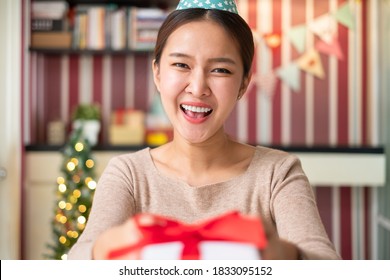 POV Asian Woman Giving Gift Or Present To Friends And Family Via Video Call Conference. New Normal For Birthday, Christmas And New Year Party