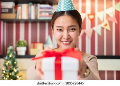 POV Asian Woman Giving Gift Or Present To Friends And Family Via Video Call Conference. New Normal For Birthday, Christmas And New Year Party