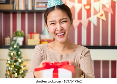 POV Asian Woman Giving Gift Or Present To Friends And Family Via Video Call Conference. New Normal For Birthday, Christmas And New Year Party