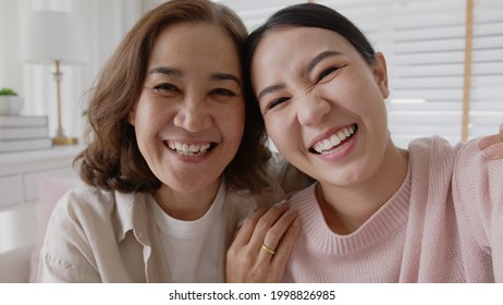 POV attractive beautiful two people asia young lady girl use mobile phone take photo picture video overjoy sit at home sofa couch have good time day together quarantine in mum healthy health care. - Powered by Shutterstock