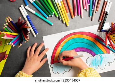 POV child painting picture and school supplies  preschool child painting  child drawing rainbow  child doing homework 