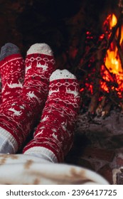 Pov of couple feet warming near fireplace at home or chalet room. Holiday vacation in christmas time. Romantic people enjoy relationship and tenderness looking fire indoor. Xmas socks red and white - Shutterstock ID 2396417725