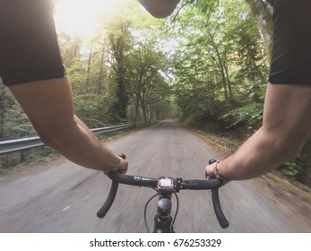 POV Cycling On A Summer Afternoon. Personal Perspective Shot Of A Young Adult Athlete Riding A Racing Bicycle At Sunset. Sun Flare Enhanced. 