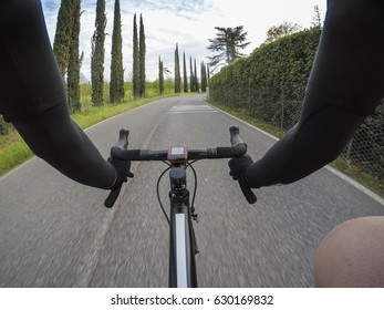 POV Cycling. Personal Perspective Of A Cyclist Riding A Racing Bicycle On A Tuscan Country Road With Cypress Trees