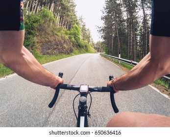 POV Cycling. Young Adult Man Climbing A Mountain Road With A Racing Bicycle On A Spring Afternoon. Personal Perspective