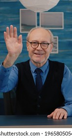 POV Of Elderly Aged Man Waving During A Video Conference With Business Partners Working From Home. Senior Person Using Internet Online Chat Technology Webcam Making Virtual Meeting Call Connection