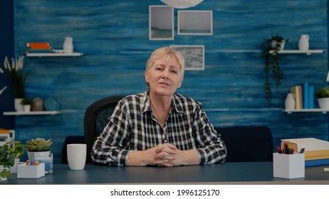 POV Of Elderly Aged Woman Waving During A Video Conference With Business Partners Working From Home. Senior Person Using Internet Online Chat Technology Webcam Making Virtual Meeting Call Connection