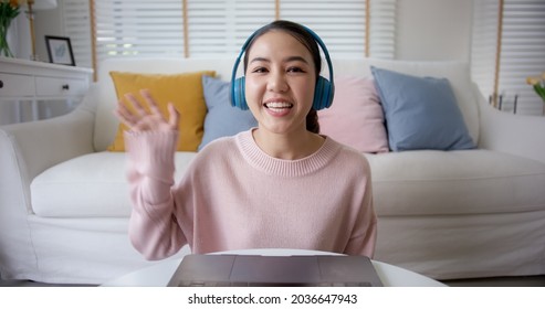 POV face selfie screen of asia people look at camera waving hand greeting sit relax at home sofa enjoy talk laugh sharing on social media online dating. Lady blogger shoot video VoIP create content.