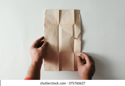 POV Of Hands Holding Vintage Paper Note On White Background