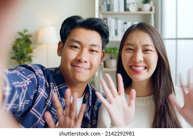 POV Happy Asian Couple Man And Woman Making Video Call, Selfie, Waving To Camera Via Mobile Phone Talking With Friends