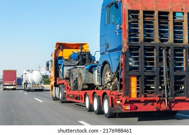 POV Heavy Industrial Truck Semi Trailer Flatbed Platform Transport Wrecked Salvage Lorry Chassis And Cabin Machine On Common Highway Road At Bright Day Sky. Scrap Collision Vehicles Disposal Service