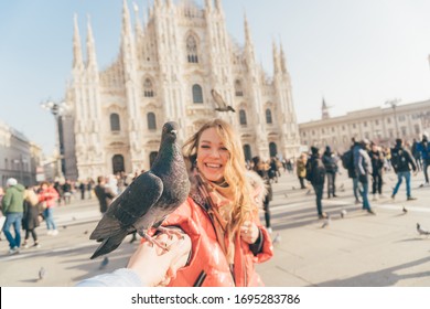 POV image of two girls best friends holding hands and making picture in the square of Milan Cathedral  (duomo di Milano) with dove sitting between them 