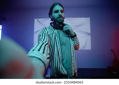 POV of long haired DJ or musician taking selfie photo in neon light, copy space - Shutterstock ID 2310484065