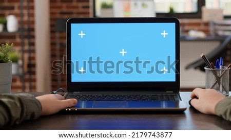 POV of male freelancer using laptop with greenscreen at office desk, working with blank mockup template on wireless pc. Looking at isolated chroma key display with copyspace background.