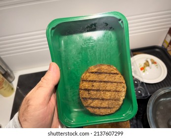 POV Male Hand Holding Green Package Wtih One Large Vegan Burger Meat
