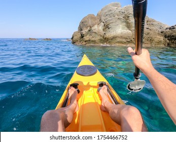 POV Of Man Floating In A Yellow Kayak Holding Paddle In Mediteraneean Sea. Point Of View Shot From Inside Kayak On Water. Kayaking In Greece. 