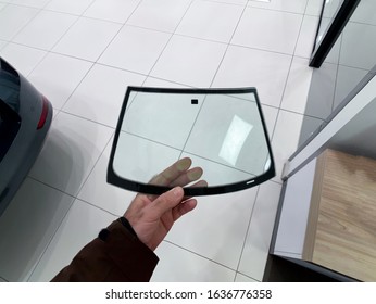 POV Of Man Hand Holding Miniature Glass Windshield Inside Car Auto Repair Shop Center