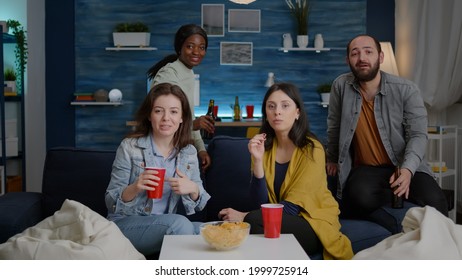 Pov Of Multi-ethnic Friends Gathering On Sofa Late At Night During Apartment Party Talking On Online Videocall Meeting With African College Friend. Multiracial People Socialising Having Fun Together