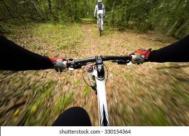 POV, Original Point Of View. Couple Of Cyclist During A Mountain Bike Race In The Forest.