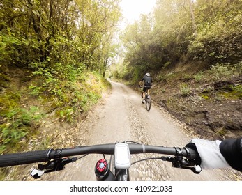 POV, Original Point Of View. Pair Of Cyclists On Mountain Bike In A Mountainous Road.