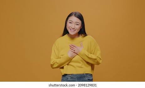 POV Of Person Waving At Camera And Talking On Video Call, Standing Over Yellow Background. Energic Woman Answering Online Conference With Webcam, Doing Remote Telecommunication.