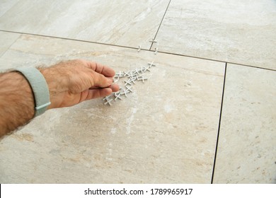 POV Personal Perspective Worker Installer Holding Multiple Tile Spacers During The Installation Of New Luxury Tiles On The Floor