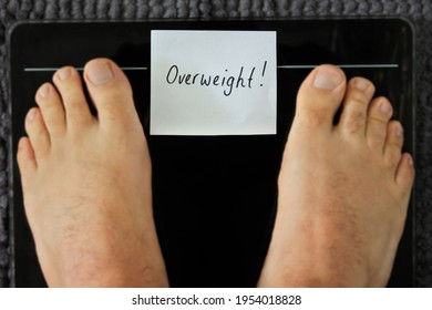 POV (Point Of View) Of A Person Standing On A Weight Scale With Sign Reading Overweight Word. Health Care Concept. Copy Space