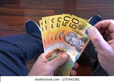 POV (Point Of View) Of Young Adult Australian Man Counting Cash Of Australian Dollar Banknotes. Economics Depression Crisis And Australia Government Welfare Benefits Payments. Copy Space