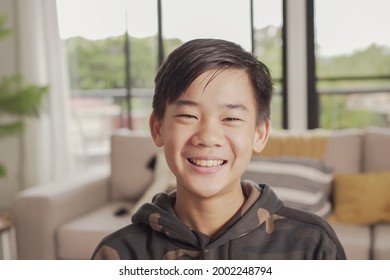 POV Portrait Of Happy Asian Preteen Teen Boy Smiling And Making Video Calling At Home, Using Zoom Online Virtual Class