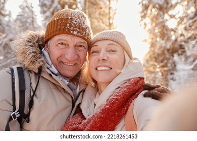 POV portrait of happy senior couple taking selfie photo while enjoying hike in winter forest - Shutterstock ID 2218261453