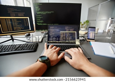 POV of QA engineer typing on keyboard while using computer at workplace in office, copy space