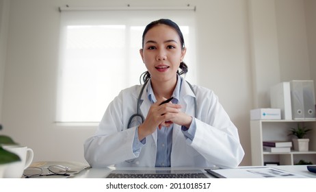 POV screen of young asia people or female doctor live speak talk look at camera work in online clinic help patient on digital telehealth telemedicine smart covid consult VoIP service app on computer. - Powered by Shutterstock