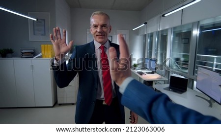 Pov shot of businessman giving high five to colleague in office. Happy entrepreneurs gesturing high-five working late.