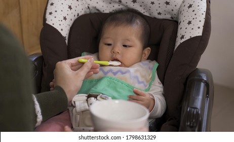 Pov Shot Of A Hungry Toddler Being Fed With Tasty Baby Food. Innocent Asian Baby Girl Loving Her Meal And Craving For More.