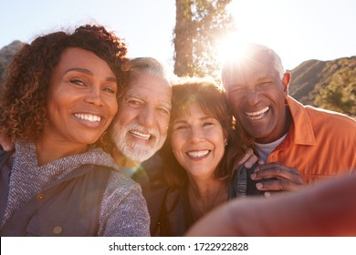 POV Shot Of Senior Friends Posing For Selfie As They Hike Along Trail In Countryside Together - Powered by Shutterstock