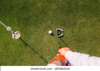 Pov Shot Of Senior Golfer At The Putting Green Hitting Ball Into A Hole