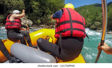 POV Shot Of White River Rafting On Rouge River. Whitewater Rafting Team Descending Raging Rapids With Paddles Splashing In Water. A Group Of People Enjoying White Water Rafting .