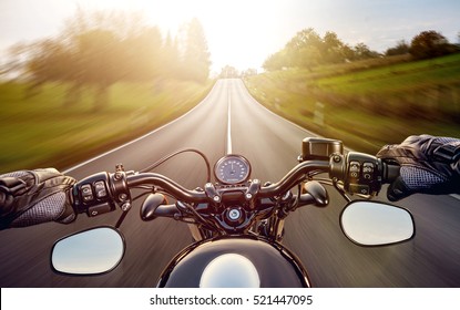 POV shot of young man riding on a motorcycle. Hands of motorcyclist on a street