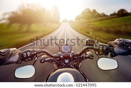 POV shot of young man riding on a motorcycle. Hands of motorcyclist on a street