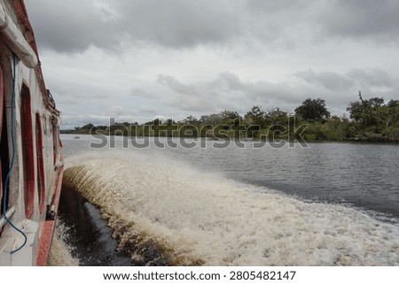 POV sideview at ship navigating tropical River in Brazilian Amazon rainforest.