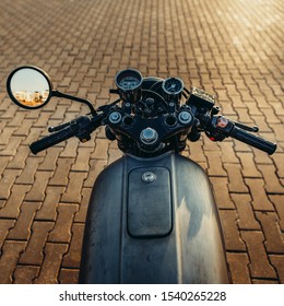 POV Silver Vintage Custom Motorcycle Motorbike Caferacer On Empty Rooftop Parking Lot With City Center With Urban Environments Midtown Buildings In Side Mirror. Hipster Lifestyle.