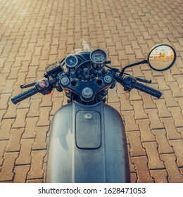 POV Silver Vintage Custom Motorcycle Motorbike Cafe Racer On Empty Rooftop Parking Lot With City Center With Urban Environments Midtown Buildings In Side Mirror. Hipster Lifestyle.