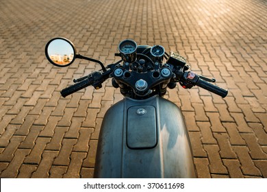 POV Silver Vintage Custom Motorcycle Motorbike Caferacer On Empty Rooftop Parking Lot With City Center With Urban Environments Midtown Buildings In Side Mirror. Hipster Lifestyle.