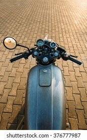 POV Silver Vintage Custom Motorcycle Motorbike Cafe Racer On Empty Rooftop Parking Lot With City Center With Urban Environments Midtown Buildings In Side Mirror. Hipster Lifestyle.