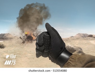 POV soldier arm using hand explosive remote.First person view soldier hand in battle gloves & tactical jacket using hand remote to explode target on desert war scene with health & armor indicator.