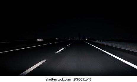 POV view of car driving on road of highway at night in Spain. Drive on an empty road in the dark evening. A car drives on a freeway. Asphalt with white line at new road.